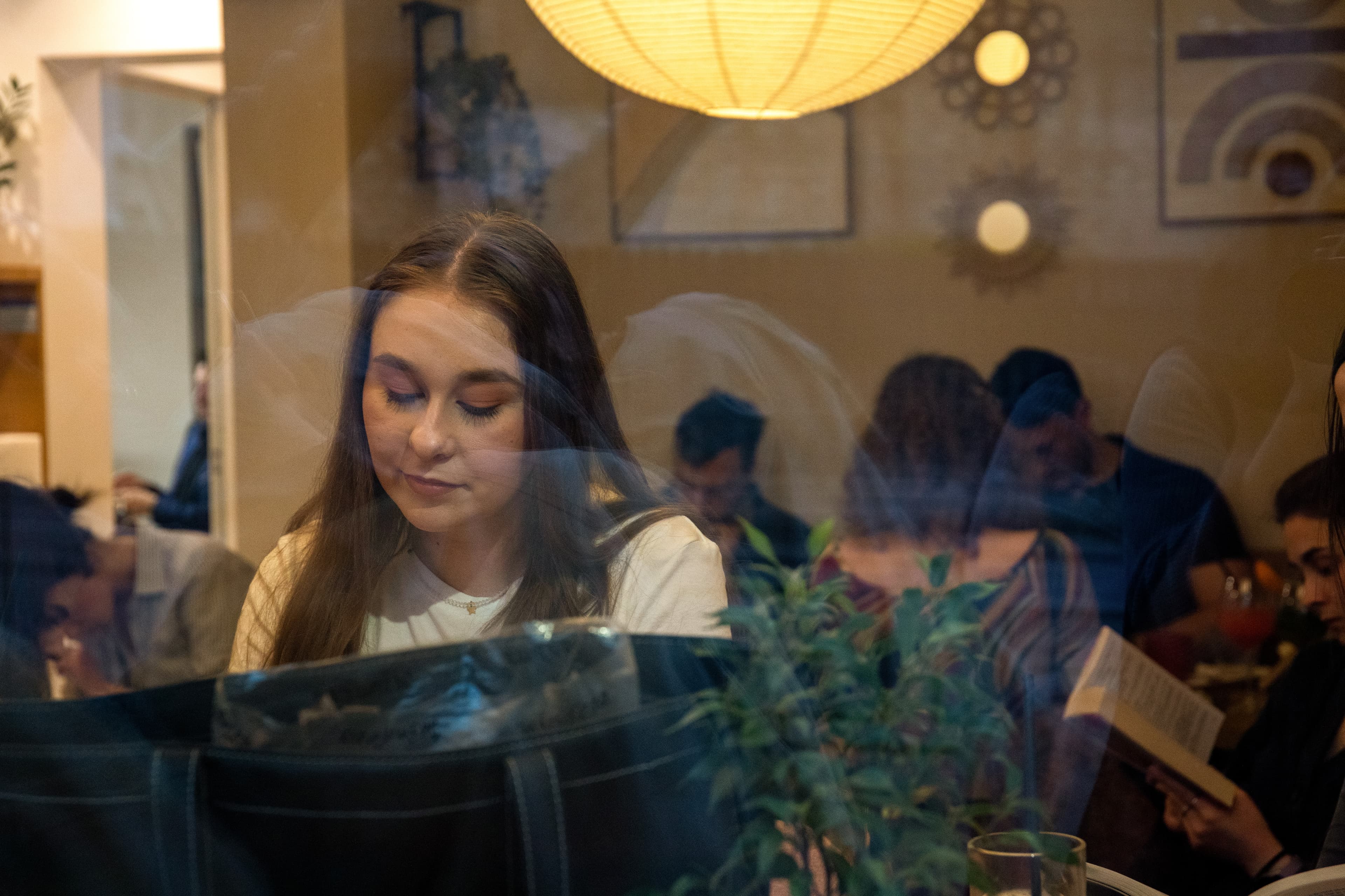 Guest absorbed in their work at Two Space, seen through the window